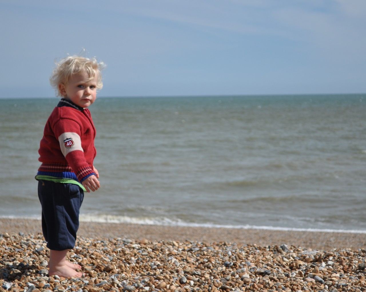 A small child on a shingle beach on the Kent coast